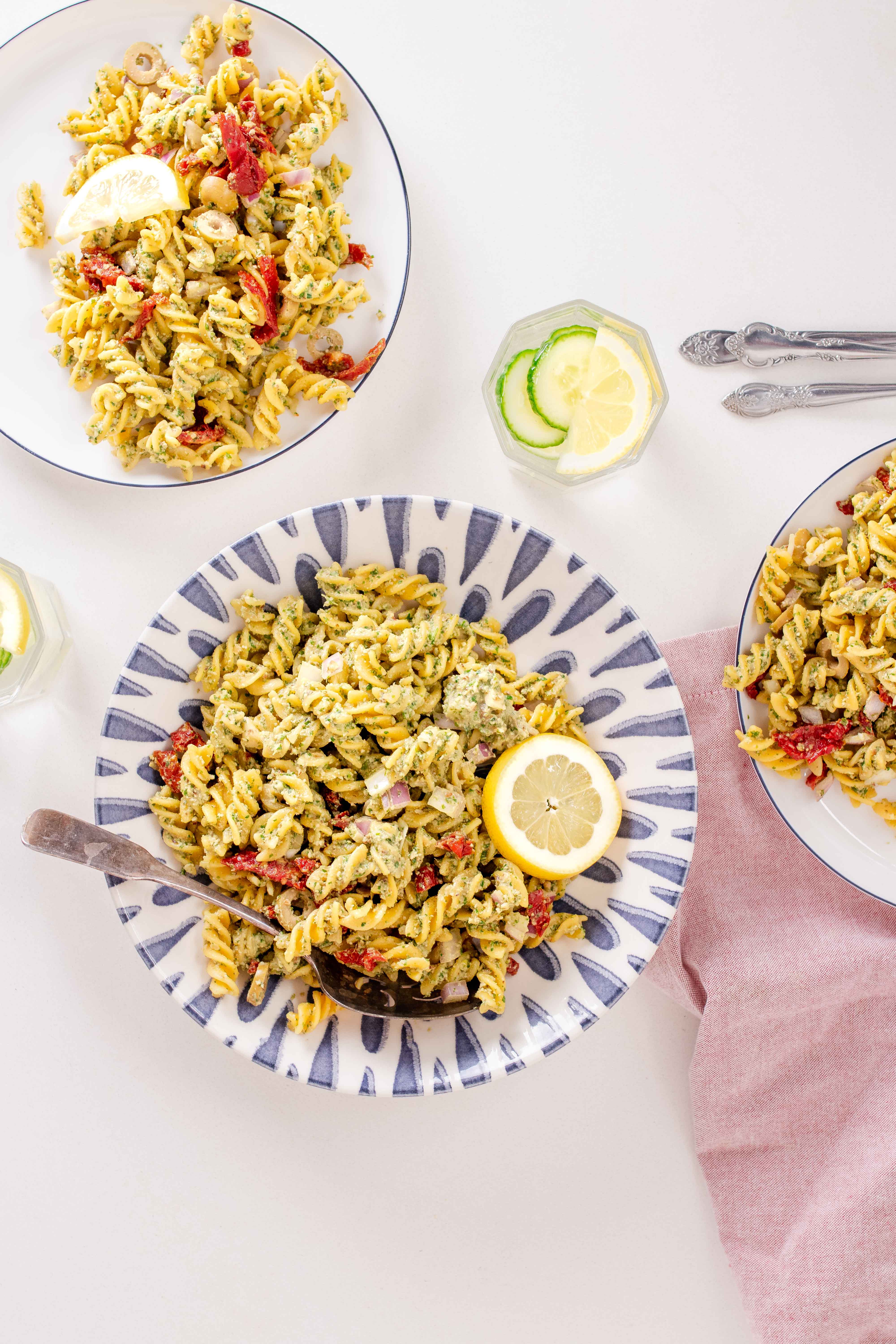 fusilli pasta with pesto, olive, sundried tomatoes, red onion and a lemon slice