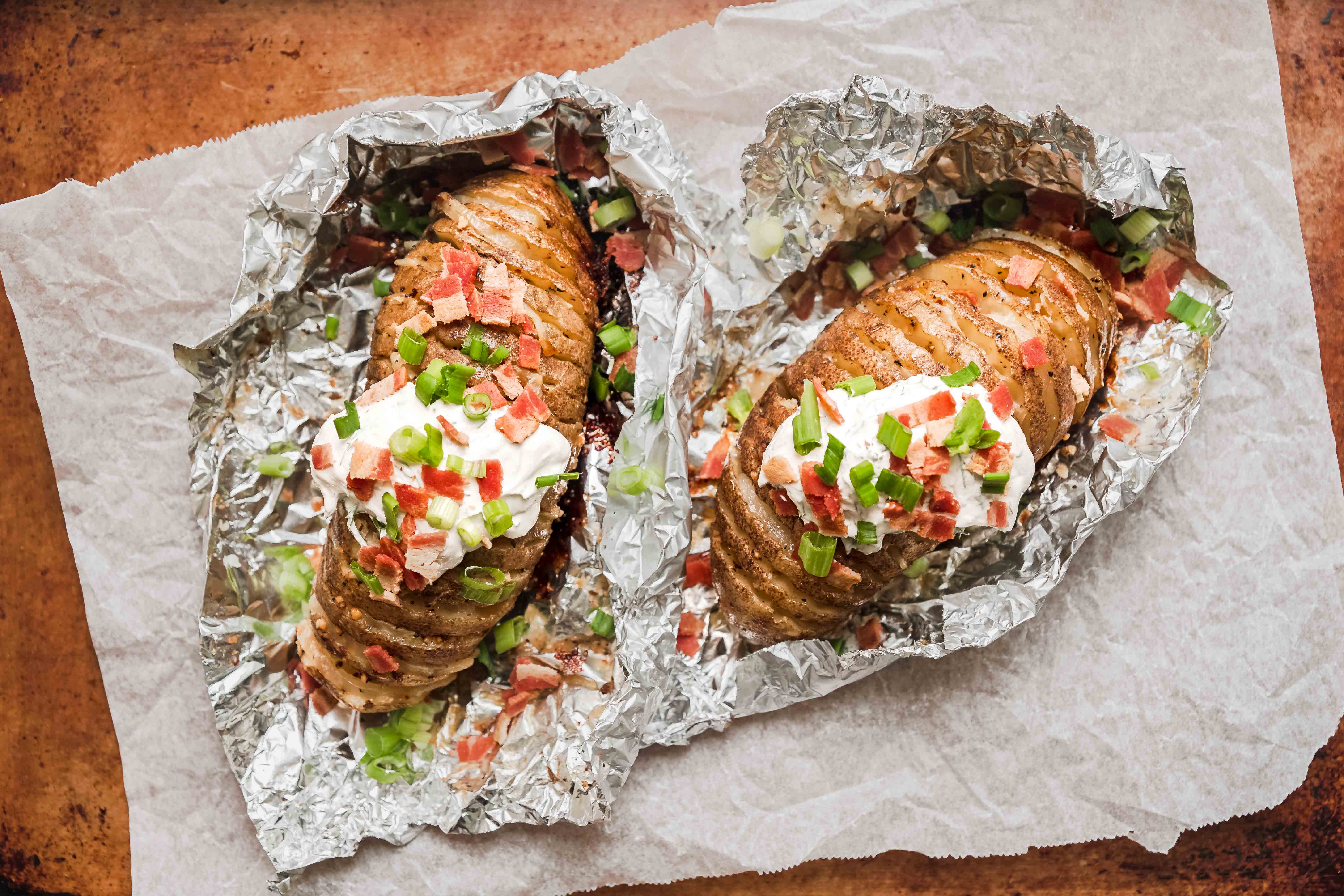 grilled hasselback potatoes with sour cream in tin foil