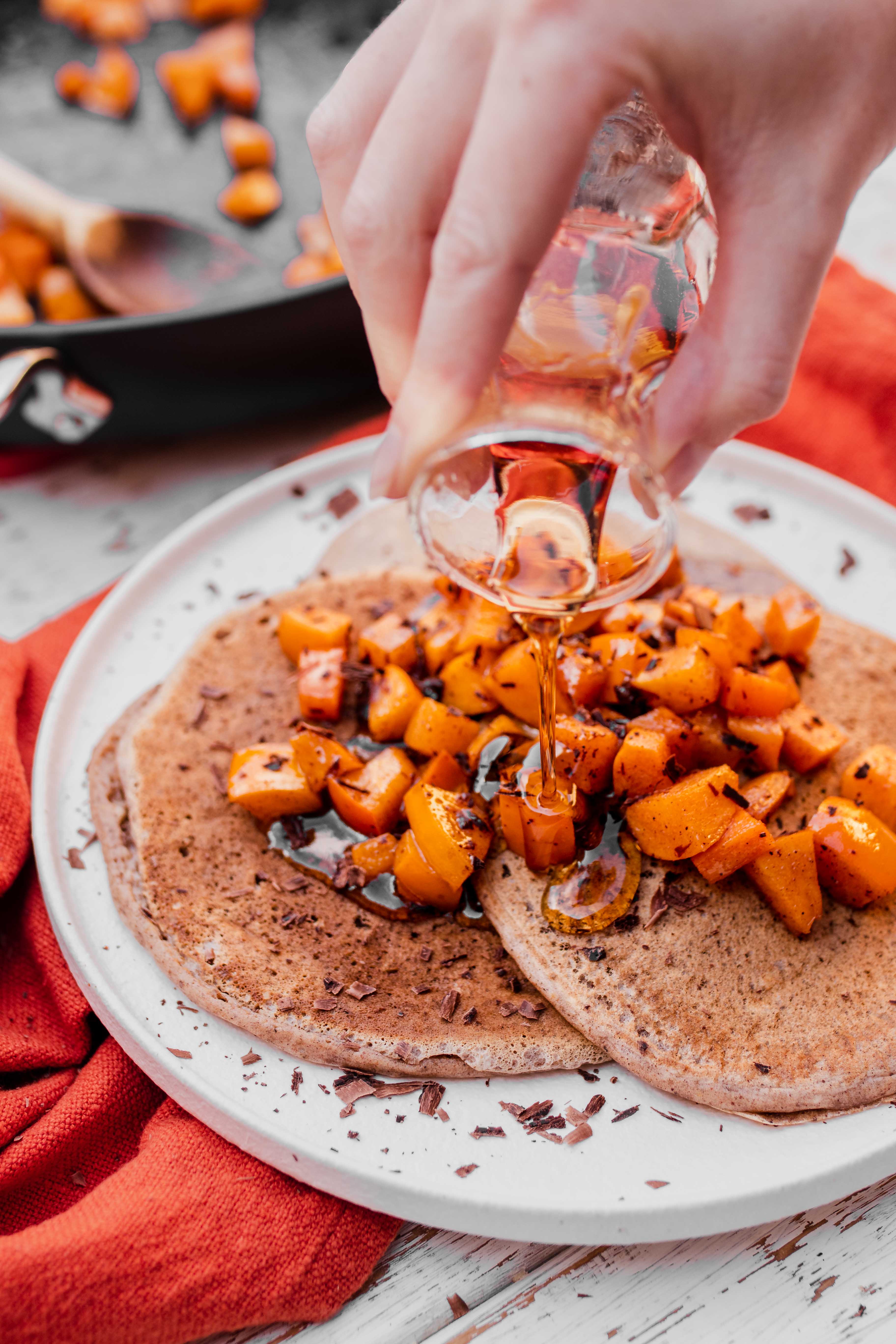 maple syrup pour over spiced pancakes with persimmons